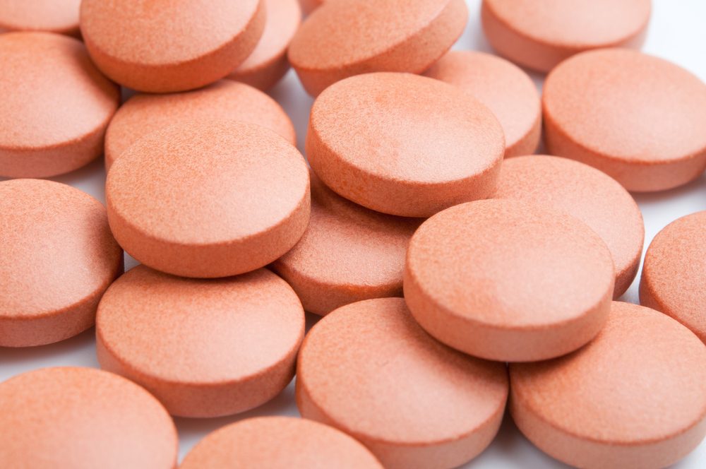 Close-up of many orange pills, selective focus.