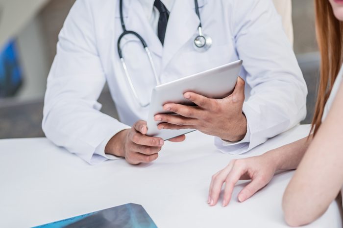 doctor with tablet talking to patient