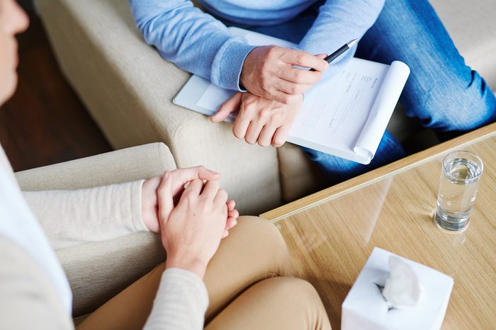 Middle-aged psychologist sitting next to a patient.