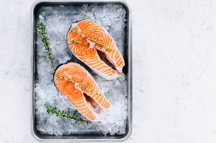 Two salmon steaks with thyme in a pan with ice.