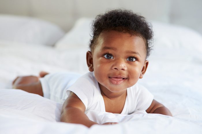 Cute baby lying on tummy in parents' bed.