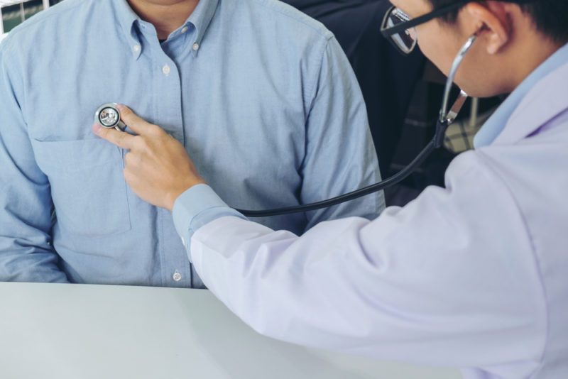 Close up of doctor listening to patient heartbeat with stethoscope on hospital, Physical examination, Medical and health care concept.