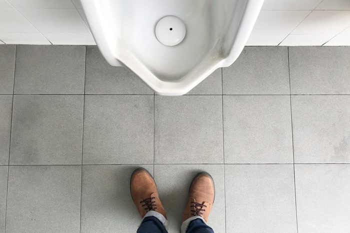 Man standing in front of urinal