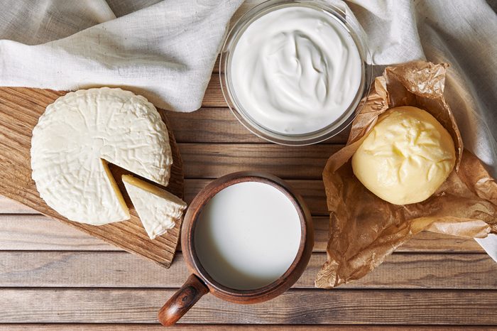 milk, cheese, yoghurt and butter on wooden background. top view