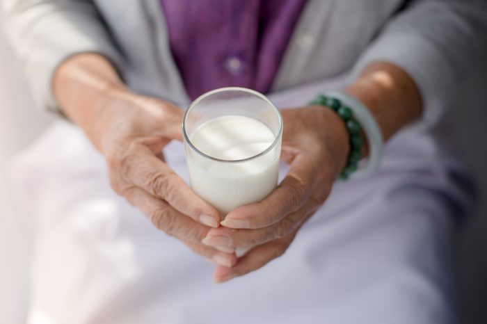 Hands holding a glass of milk