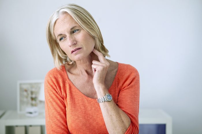 woman touching lymph nodes in neck