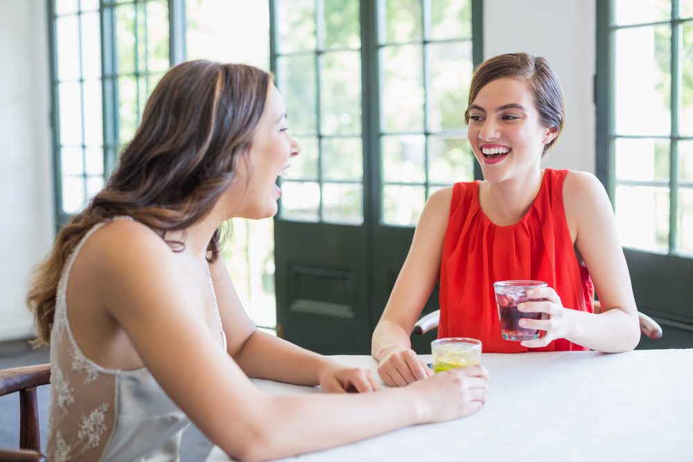 Friends laughing while having cocktails