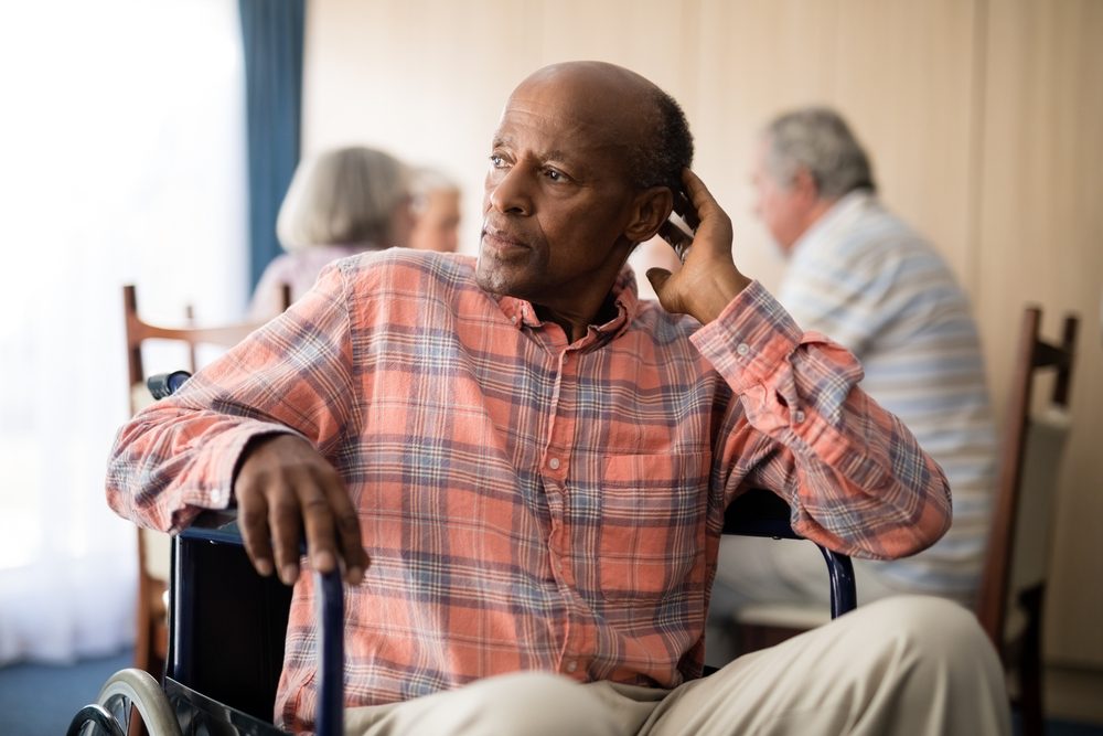 Thoughtful senior man sitting in wheelchair at retirement home