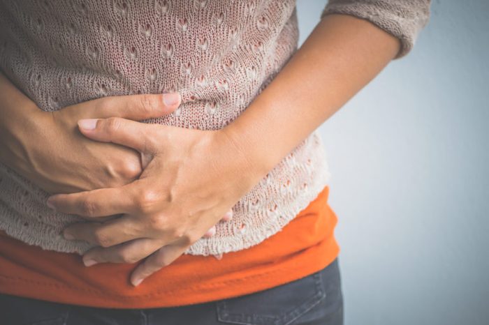 woman holding hands over stomach