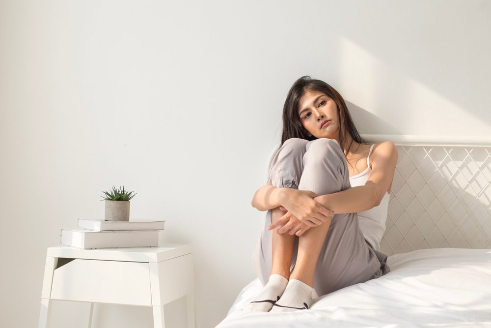 sad woman sitting on bed