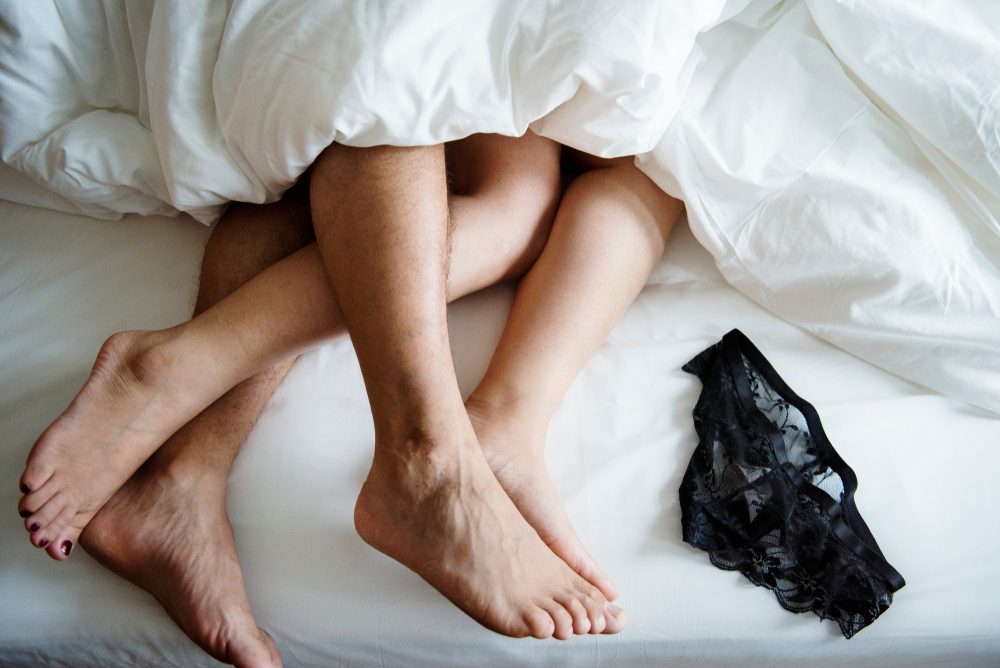 Legs of a couple sleeping in bed