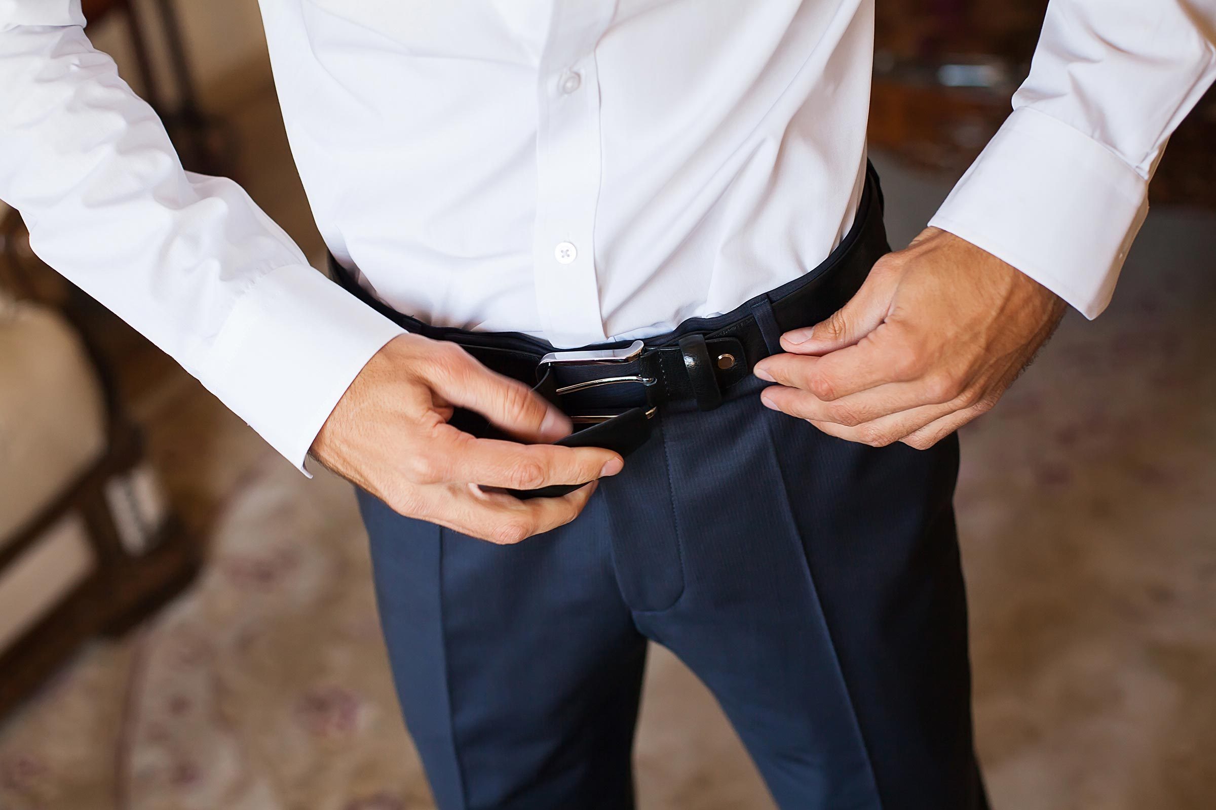 man tightening his belt