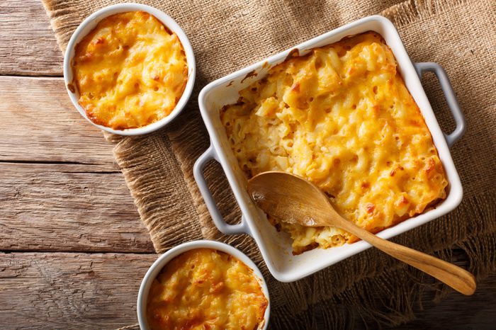 American casserole macaroni and cheese in baking dish close up on the table. Horizontal top view from above