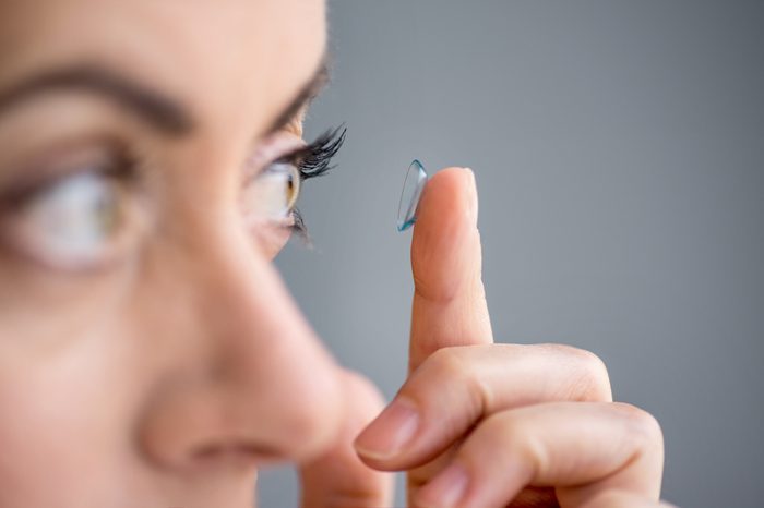 woman in her forties inserting contact lenses