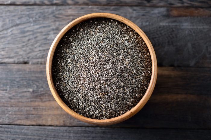 Bowl of chia seeds on a wooden surface.