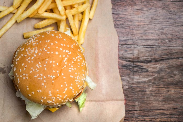 still life with fast food hamburger menu, french fries on wood desk