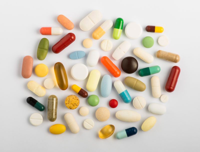 vitamins and supplements pills overhead studio gray background