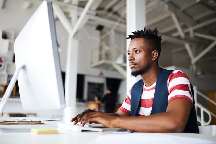 Man sitting at his desk looking at his computer monitor.