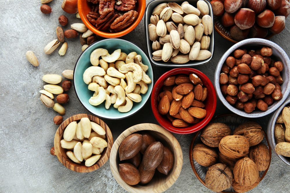 mixed nuts on grey background. Healthy food and snack. Walnut, pecan, almonds, hazelnuts and cashews