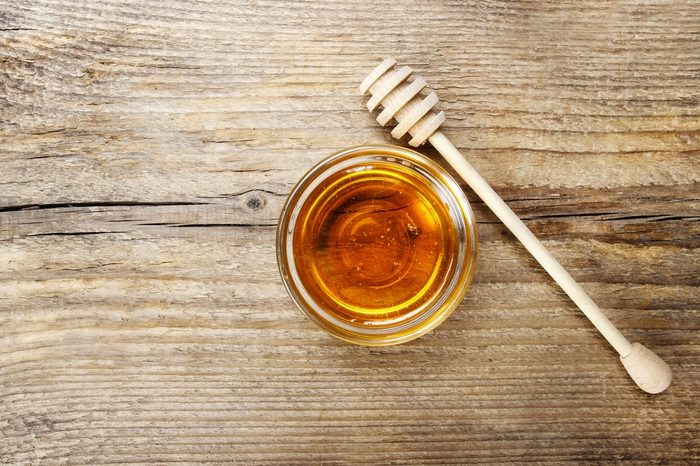 Bowl of honey on wooden table. Symbol of healthy living and natural medicine. Aromatic and tasty. Top view.