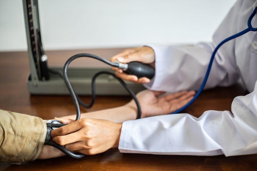 Cropped image of female Doctor checking old man patient arterial blood pressure.Selective focus .Health and Medical concept