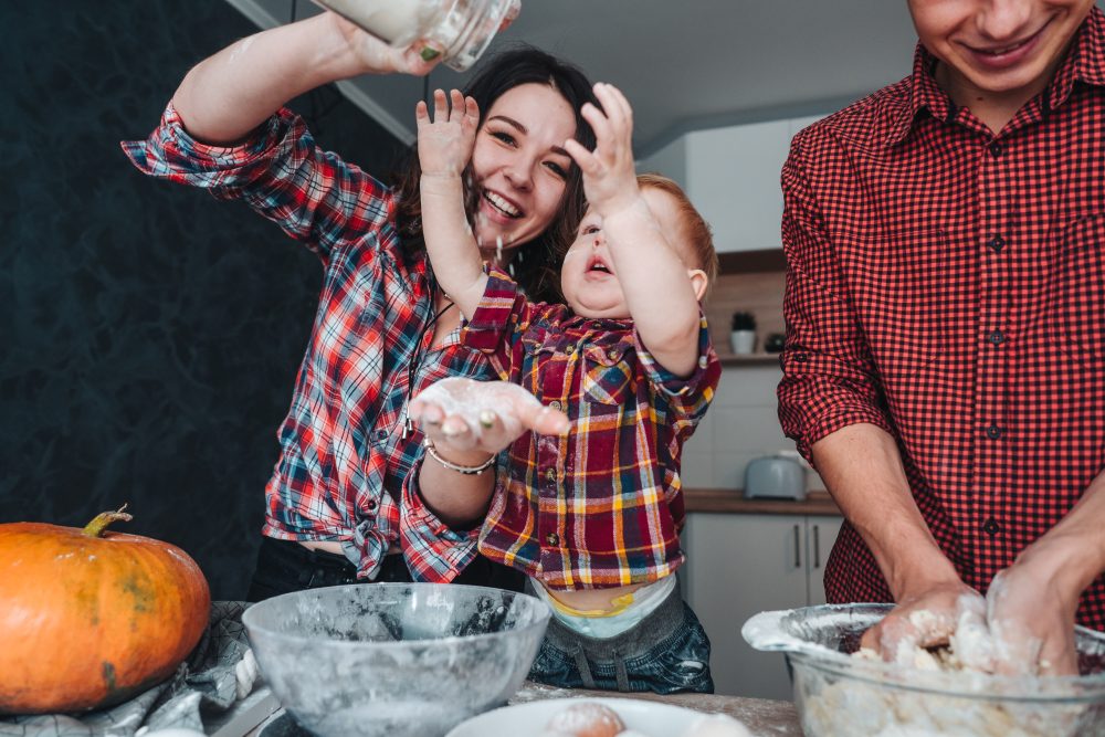 Dad, mom and little son in the kitchen, cook a pie