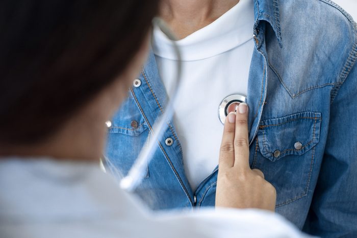 Doctor checking patient's heartbeat with a stethoscope at a hospital.