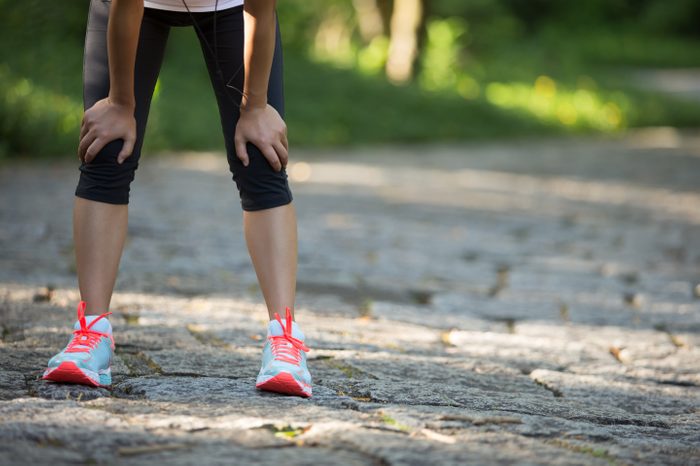 female runner hands on knees tired