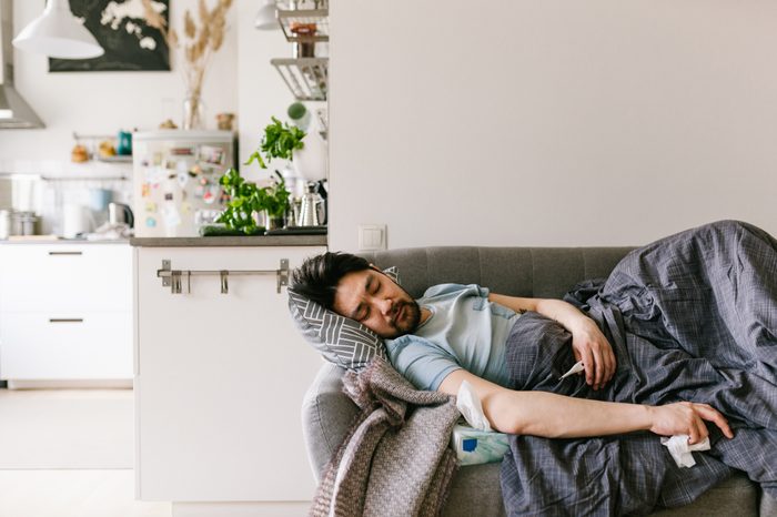 man sick with a cold on the couch