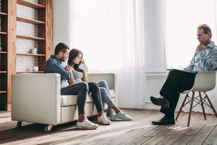 Young couple at a psychologist's reception. Solving family problems. Senior experienced psychotherapist