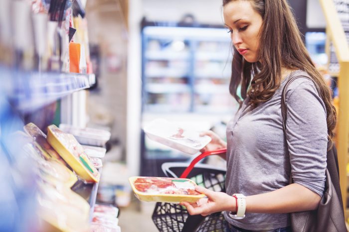 woman grocery store shopping meat frozen chicken