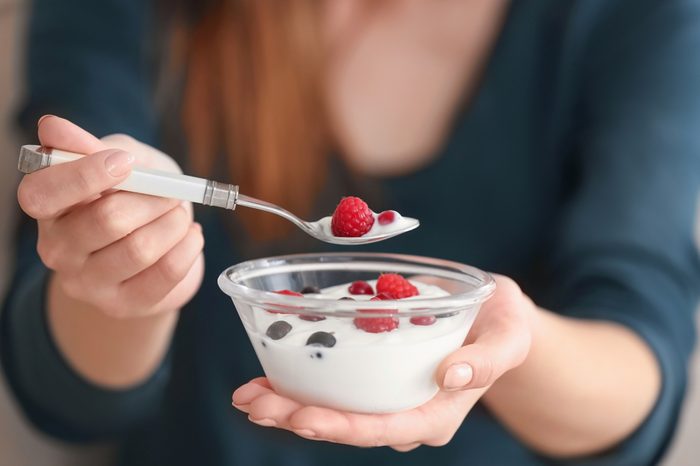 Young woman eating yogurt, closeup