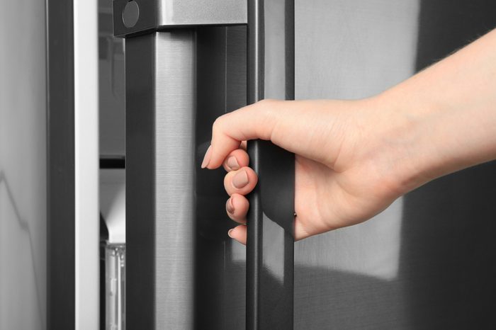 Woman opening refrigerator door, closeup