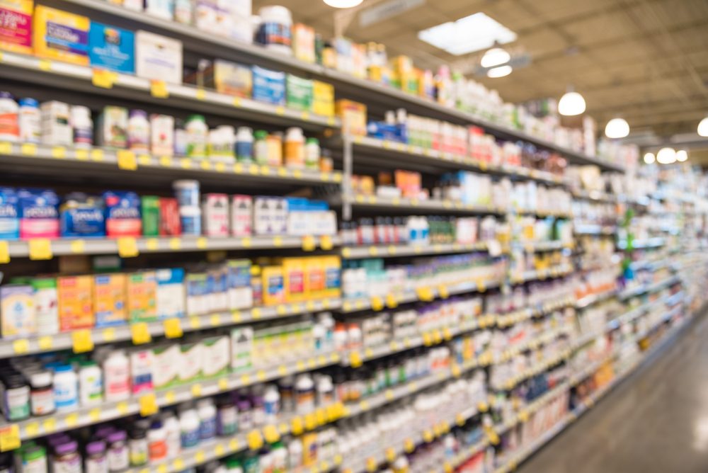 Blurred image of vitamin store shelves with huge variation of vitamins and supplements, natural remedies, functional food, lifestyle support, and herbal. Medical supplies product abstract background.