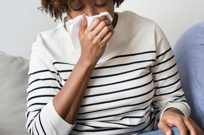 Woman blowing her nose into tissue