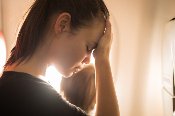 woman tired headache airplane flight flying