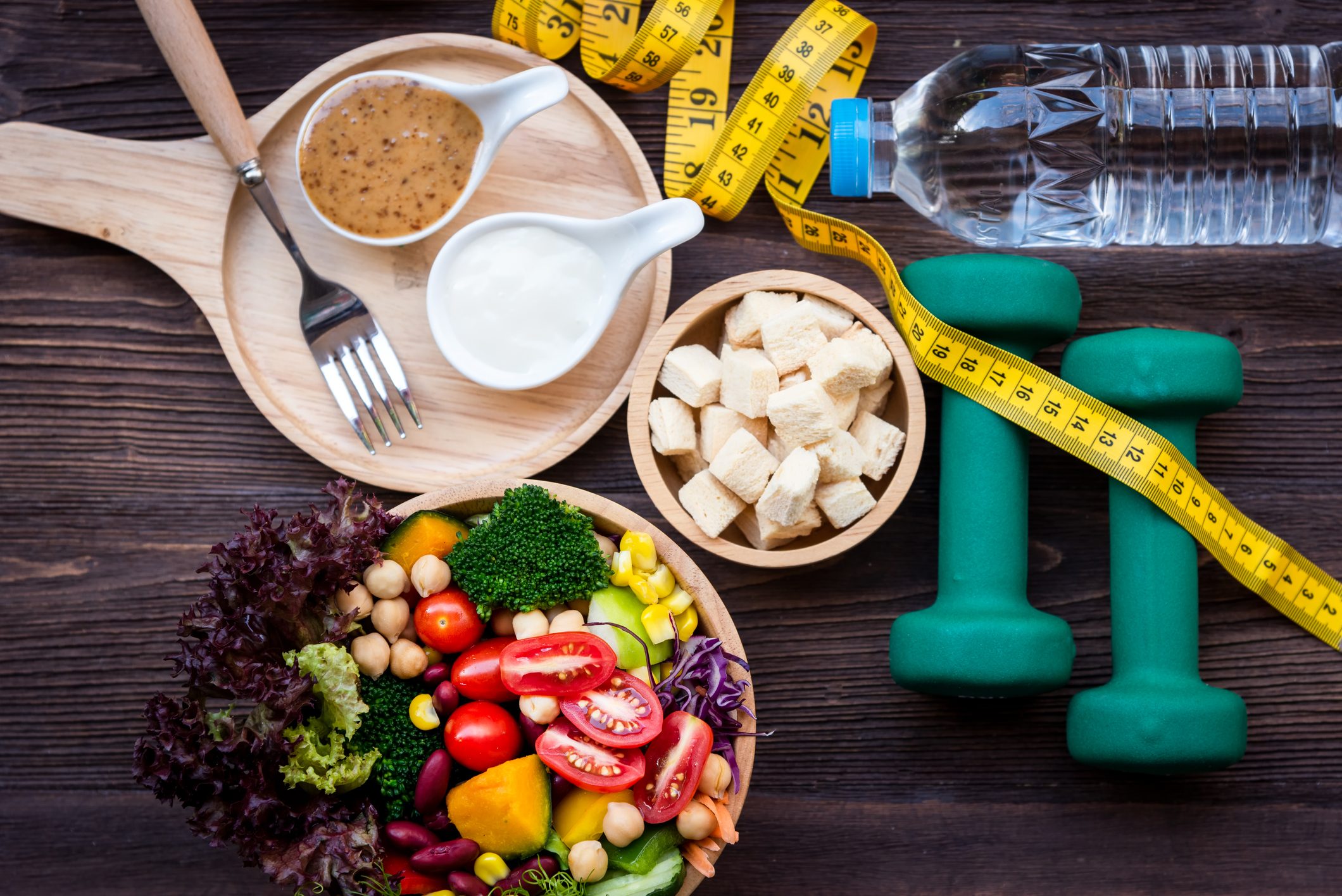 fresh vegetables, tofu, measuring tape, weights, and watter; weight loss concept