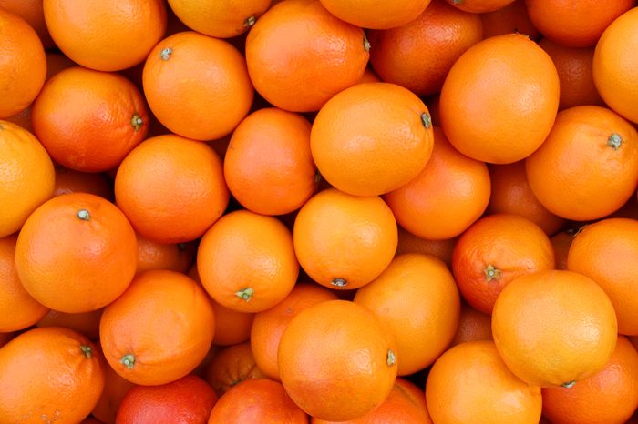 background of juicy ripe oranges freshly picked from the orchard tree