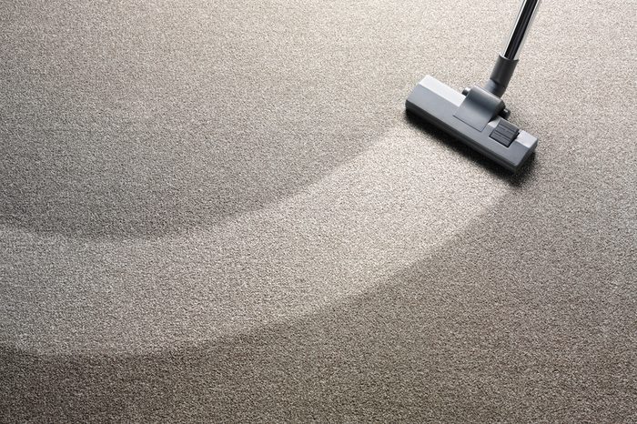 Vacuum cleaner on a carpet with an extra clean strip for copy space