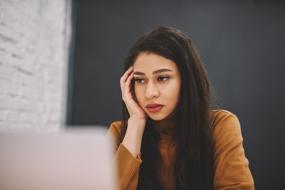 Bored unhappy young woman watching tutorial on laptop computer depressed with exam preparation problems, sad hipster girl worried about bad information read from networks stressed with troubles