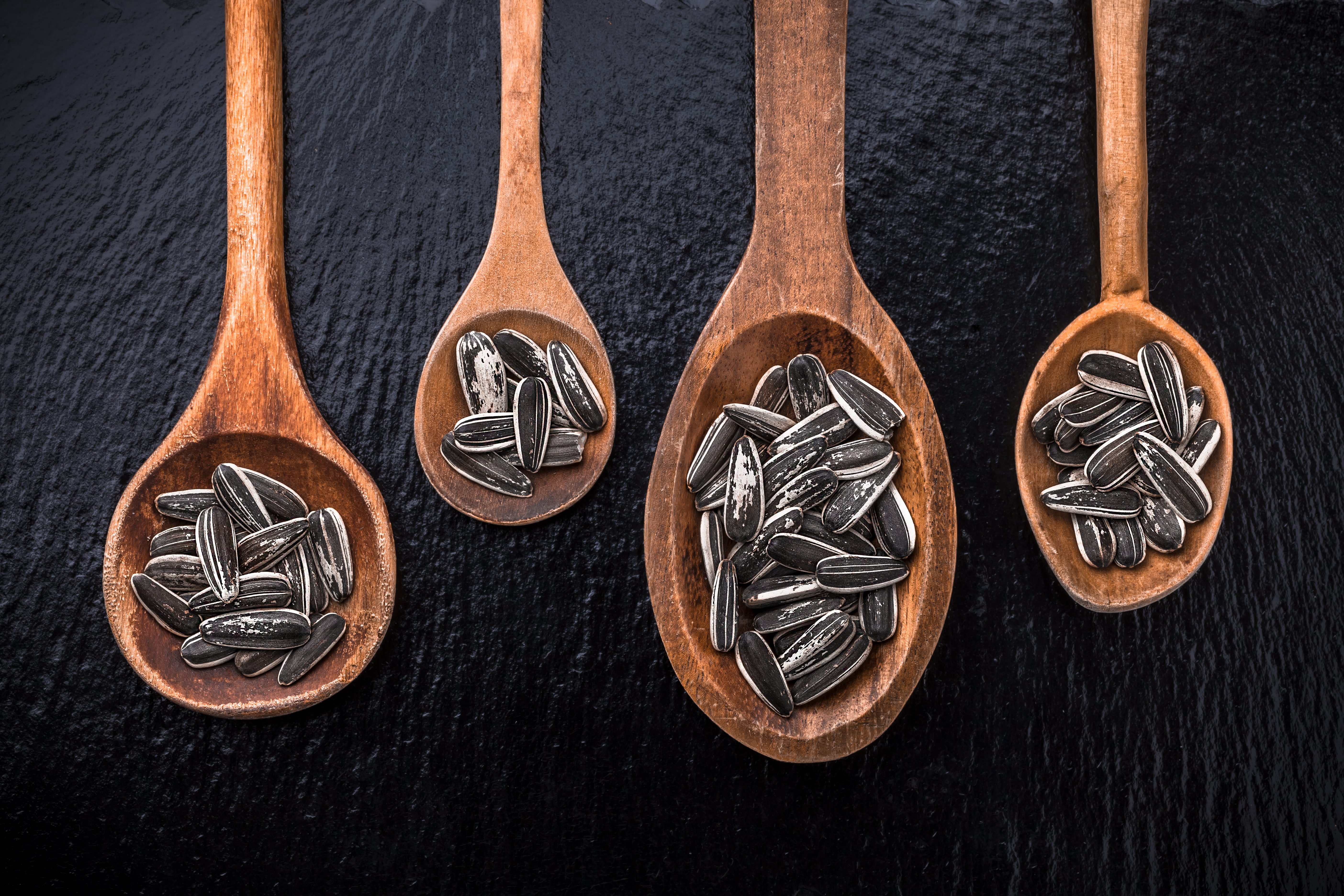 Sunflower seeds in large wooden spoons