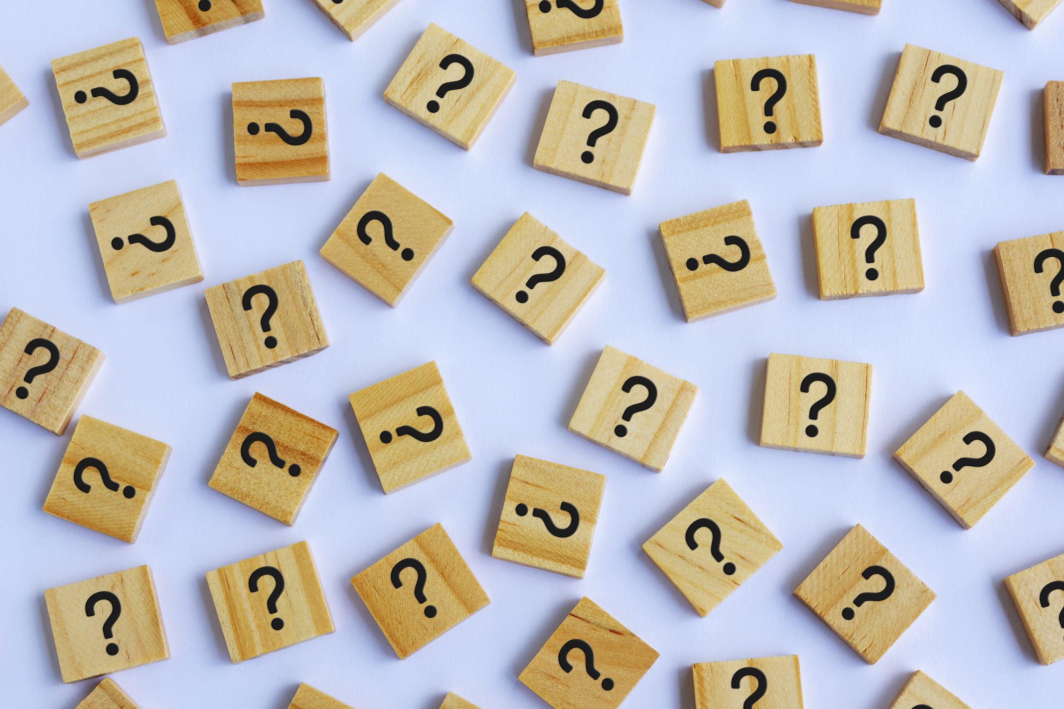 wooden blocks with question marks on light purple background