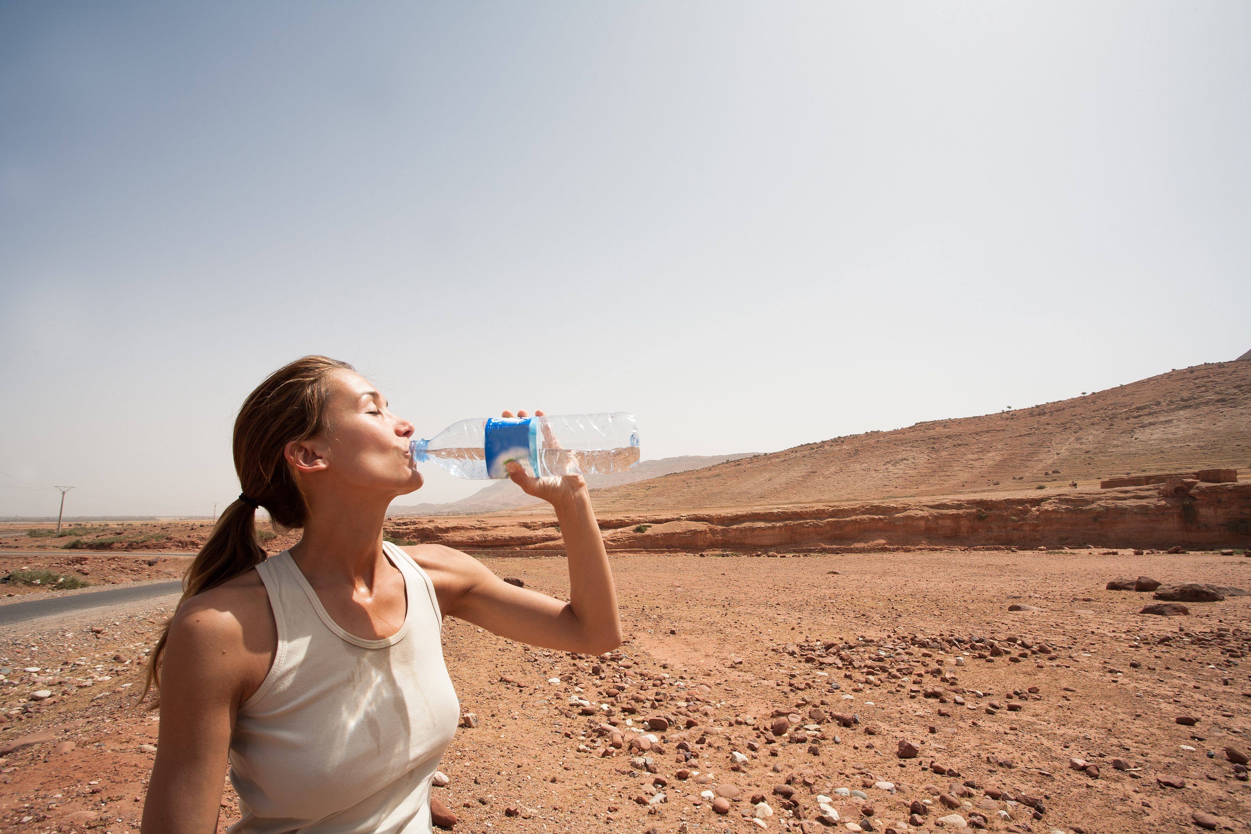 woman drinking water in the desert