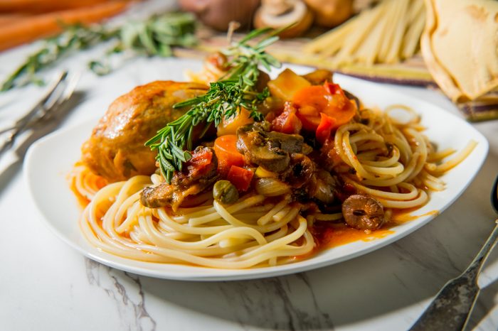 Italian chicken Cacciatore hunter's stew with spaghetti noodles and crusty bread