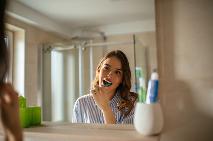 young woman brushing her teeth