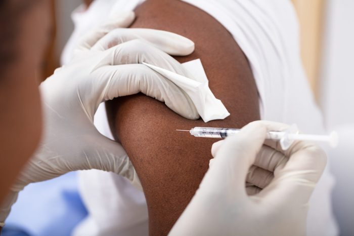 Close-up Of A Doctor Injecting Syringe To Male Patient's Arm In Clinic