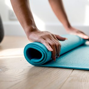 woman rolling up yoga mat