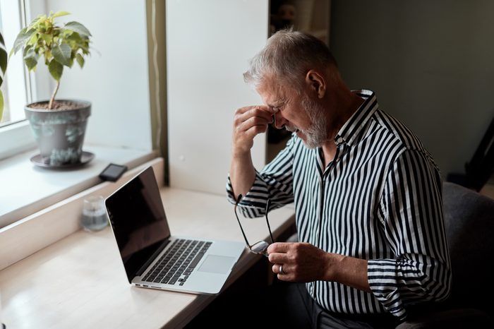 Photo Of Tired Mature bearded man sitting in front of laptop