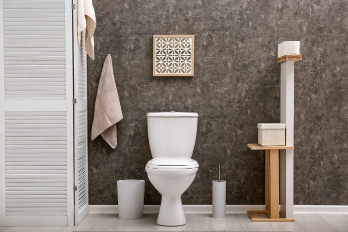 Toilet bowl near dark wall in modern bathroom interior