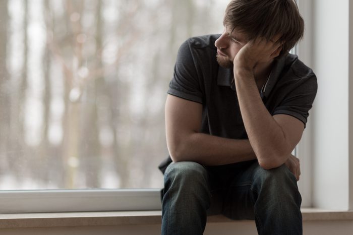 Young miserable depressed man sitting and thinking